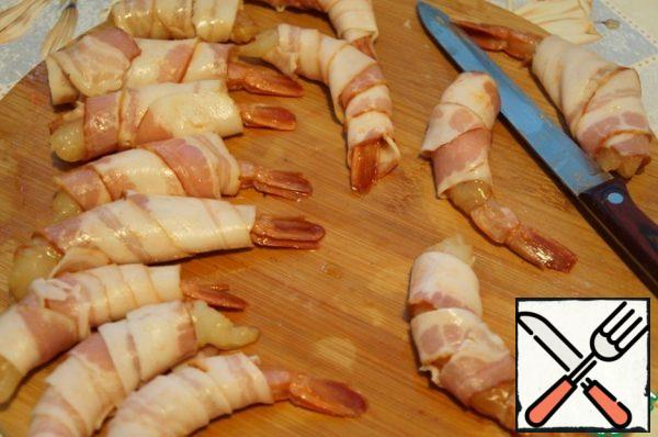 Wrap each shrimp in a strip of bacon (you can cut the strip lengthwise, I tried both ways).
In a small amount of olive oil, fry the prawns over medium heat for 1.5-2 minutes on each side.