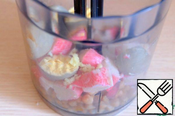Crab sticks (5 pieces) cut into pieces. In a blender, add the chopped crab sticks, egg yolks, garlic clove passed through a garlic press, canned beans, salt and black pepper to taste, and puree all the ingredients until smooth and creamy.