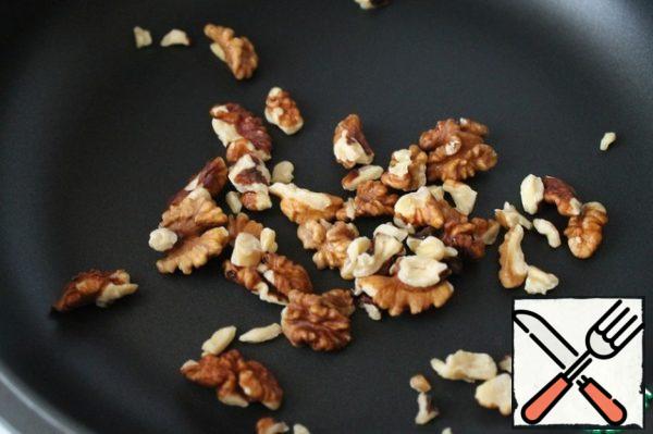 Lightly brown the nuts in a dry pan.