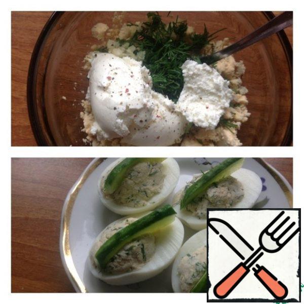 Chop the yolk with a fork. Add to it cottage cheese, garlic passed through a press, salt, pepper and dill finely chopped. Mix everything thoroughly. If desired, you can add a spoonful of mayonnaise. Stuff the eggs with the filling. Cut the cucumber into slices and stick it in the center of each half of the egg. Garnish with a sprig of dill.