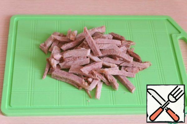 Boil the meat (beef) in salted water. Cut into thin slices.