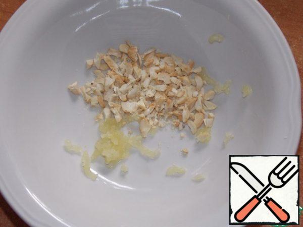 Squeeze the garlic through a garlic press, add the nuts.