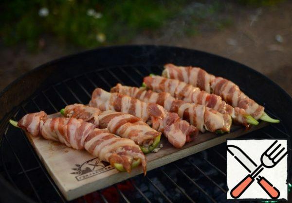 Then turn the grill board face up and place the stuffed peppers on top. If there is a lid - cover and bake for 15-20 minutes until golden brown. If there is no lid-bake for 20-30 minutes, the board should smolder, but not burn (keep a spray bottle or a bottle of water ready)!