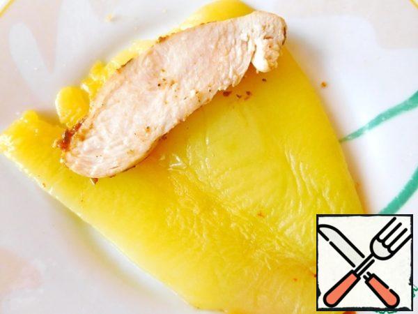 The finished chicken fillet is cut into slices and spread on half of the pepper.