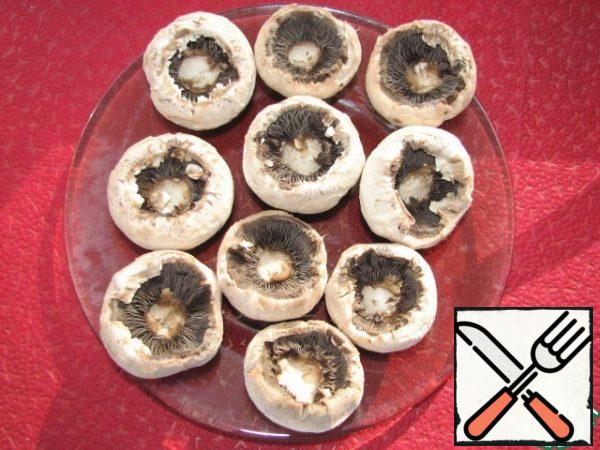 Remove the skin from the mushrooms, cut out the legs (we will not need them).