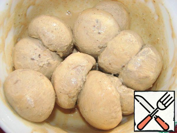 Pour the marinade over the mushrooms, close the cup with a lid and shake well several times. Put in the refrigerator to marinate.
While the filling is being prepared, the mushrooms will be marinated.