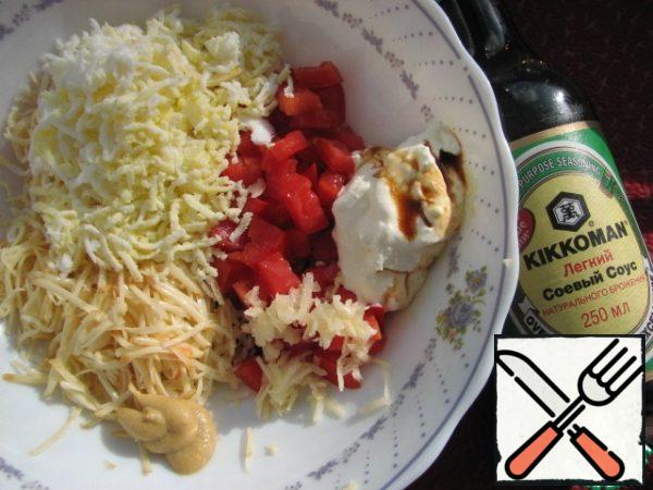 Prepare the filling.
Boil the egg and let it cool. In a cup on a fine grater, rub the sausage cheese, egg and garlic. Peel the tomato from the seeds, cut into cubes.
Add mustard, 1 tbsp sour cream and 1 tbsp soy sauce.
Mix everything well.