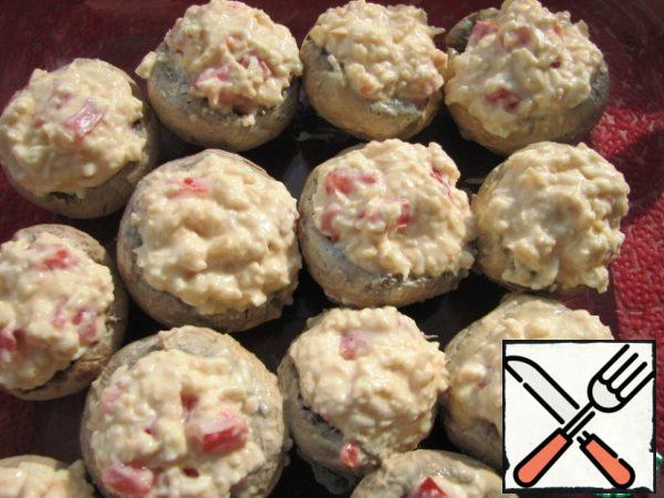 The resulting mass is stuffed with mushroom caps (with a slide). Put in a preheated 180 degree oven for 35 minutes.