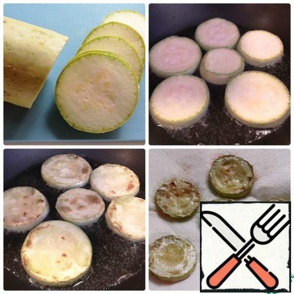 Cut the zucchini into small circles. Add salt and fry in vegetable oil on both sides until tender.
Transfer to a paper napkin. Let it absorb the excess oil.
