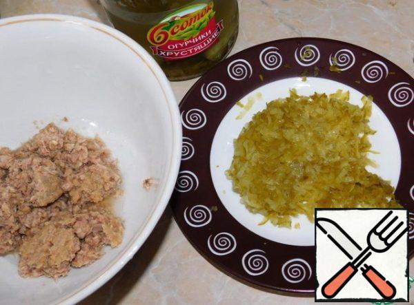 Mash the tuna with a fork and add the grated pickled cucumbers to it.
