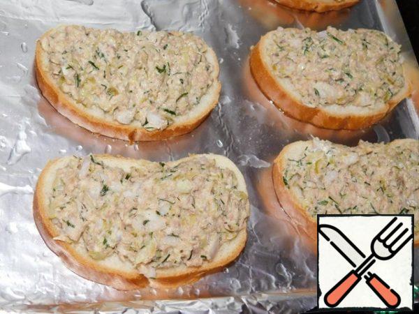 On a baking sheet, pour vegetable oil and spread the pieces of the loaf with the finished spread. Thanks to the fact that the oil is poured in the end, we will get sandwiches on toasted croutons. It will be very tasty!