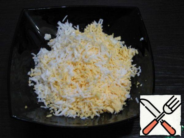 Boil the eggs, grate them on a fine grater.