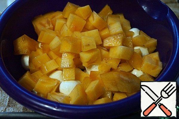 Cut the persimmon in half, release the pulp, cut into cubes, add to the tangerines and cheese.
