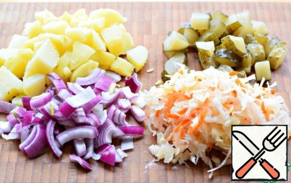 Cut the potatoes into arbitrarily large pieces.
Cucumber is also cut into large pieces.
Onion-quarter-rings.
Lightly squeeze the cabbage from the brine.
(I recommend large cuts of vegetables for this salad).