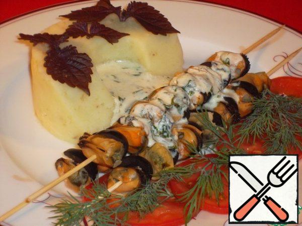 You can submit it like this:
In this case, string the mussels with halves of olives on bamboo skewers, pour the sauce and serve with a potato garnish (I have mashed potatoes) as a main course…