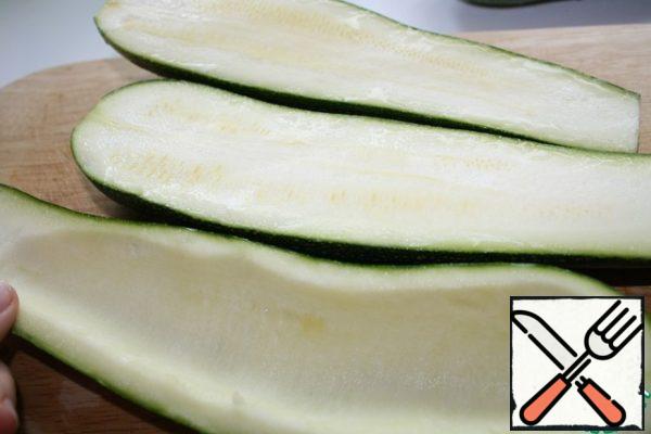 Wash the zucchini, cut it in half lengthwise and carefully clean the pulp with seeds with a spoon.
Then boil in salted water until soft. I put them in boiling water.
Cook for no more than 5 minutes after the water boils.