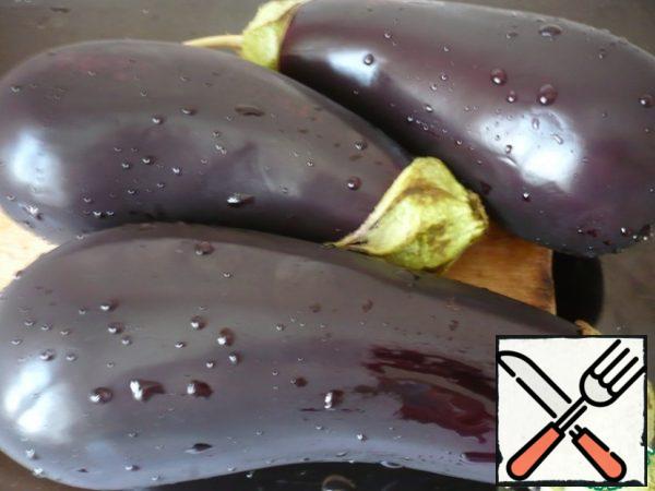 Wash and dry the eggplants, you do not need to clean them. Remove only the tails.