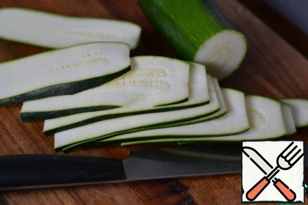Cut the zucchini into thin strips.
Lightly season with salt and pepper.