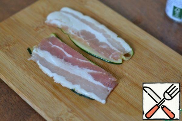 On each strip of zucchini spread a strip of bacon.