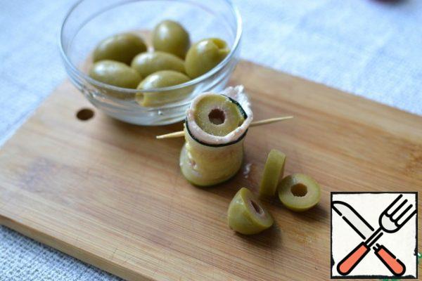 Cut the olives.
Insert one piece into the roll.
