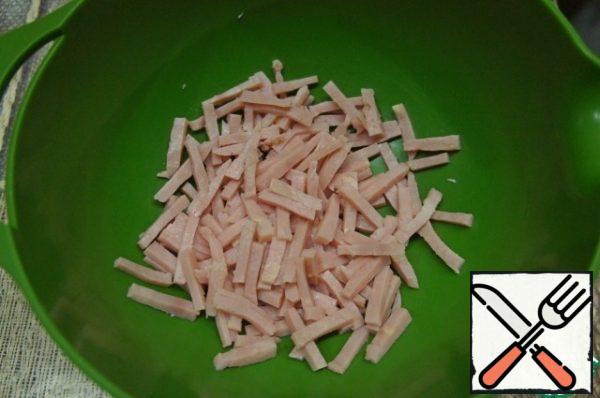 Cut the ham into strips and pour it into a deep bowl.