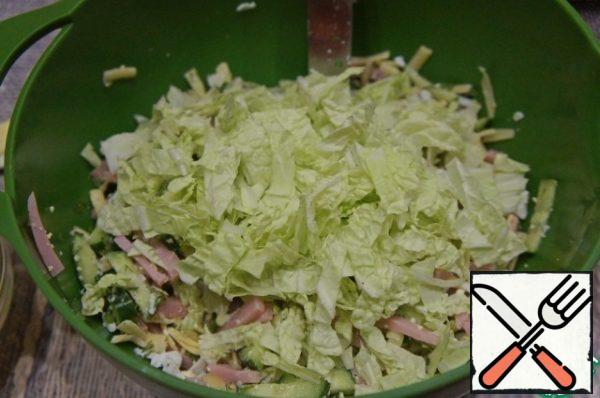 Peking cabbage leaves cut into wide strips and pour into a bowl with the salad.