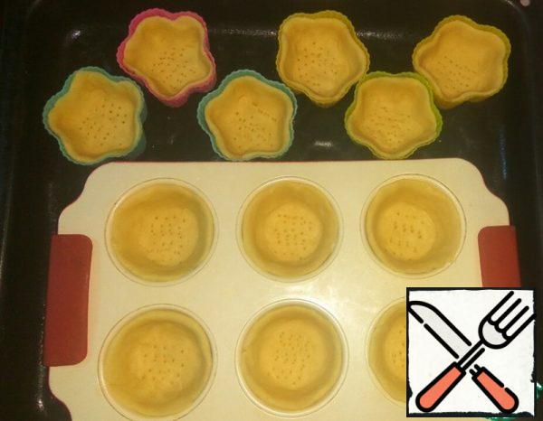 From the dough, pinch off small pieces and distribute them on the molds, pressing the bottom and sides well. Prick the bottom with a fork. Bake in a preheated 170 degree oven for about 15 minutes until light straw color. Strongly browning tartlets is not necessary.