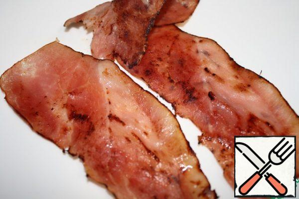 So, we'll need bacon.
It should be fried until crunchy, put on a napkin and then cut into strips.