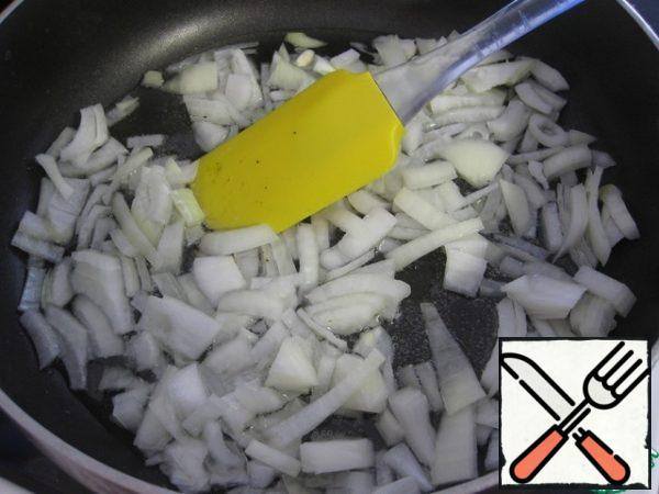 In a frying pan, heat the oil, cut the onion into cubes and fry until soft.