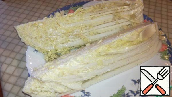 In a bowl, mix olive oil, lemon juice, water, finely chopped garlic, salt and pepper to taste. Mix well. Pour our cabbage and leave for 10 minutes.