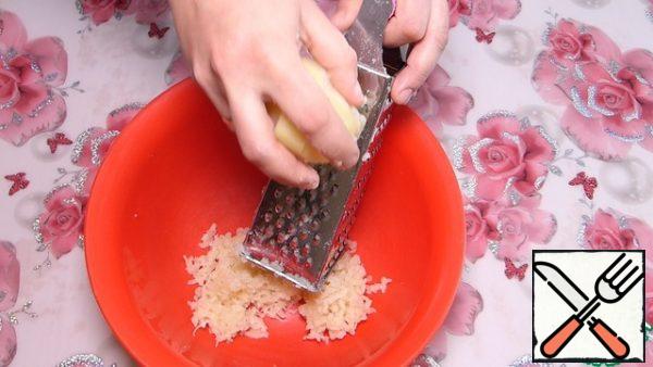 Potatoes are boiled in the "uniform". Clearing it.
Grate on a fine grater.