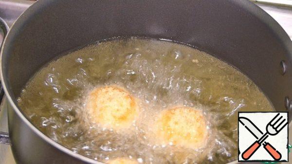 From this amount of ingredients, I got 17 balls.
We lower the balls into the hot vegetable oil in 3-4 pieces (I have a small saucepan to save oil) and fry until golden brown on all sides for about 40-50 seconds.
We spread the finished balls on paper towels to remove excess oil.