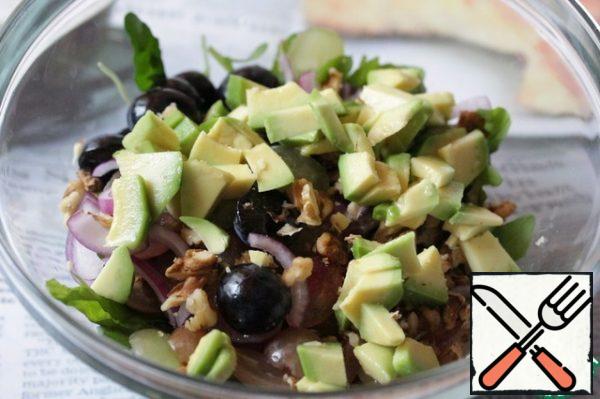 Peel the avocado, cut into cubes, sprinkle with lemon juice and add to the salad.