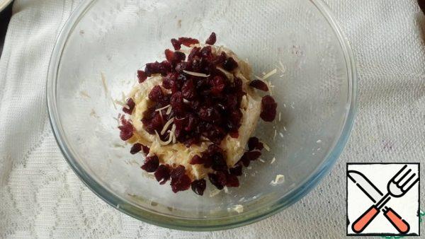 Grate the hard cheese on a fine grater. Add cream cheese and sauce. Mix well.
Add the cranberries. Mix well.