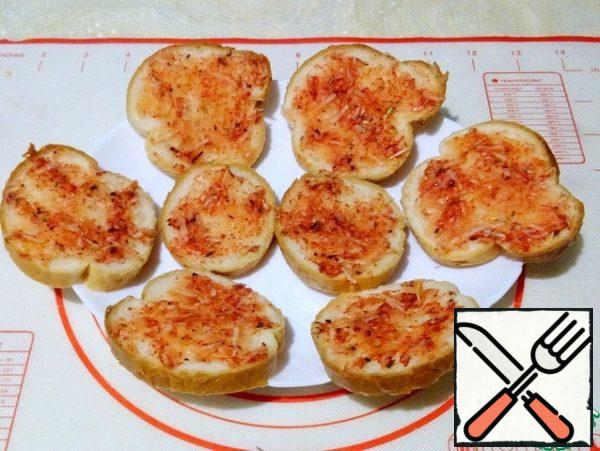 Spread the garlic sauce over the baguette slices.