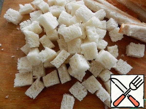 Loaf (I usually take toast bread) cut into cubes with a side of about 1 cm.
In a bowl, mix 2 tablespoons of olive oil, a couple of pinches of salt and garlic, chopped on a fine grater.