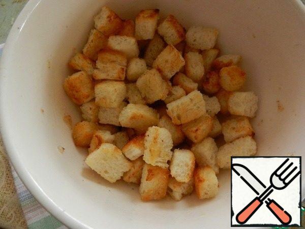 Blanks from a loaf (bread) fry in a dry pan until browned. Put in a bowl, add the oil-garlic mixture and mix. We will get fragrant delicious crackers, which must be placed on top before serving the salad.