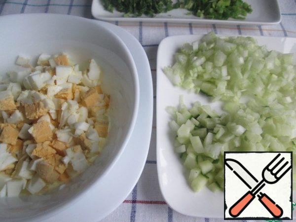 Finely chop the eggs.
Cut the cucumber and celery into small cubes. Cucumber, if desired, can be cleaned.
Finely chop the dill and green onions.