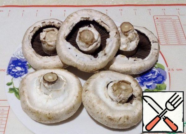 Wash the mushrooms and wipe them with a paper towel. Remove the skin, it is easily removed and remove the leg.