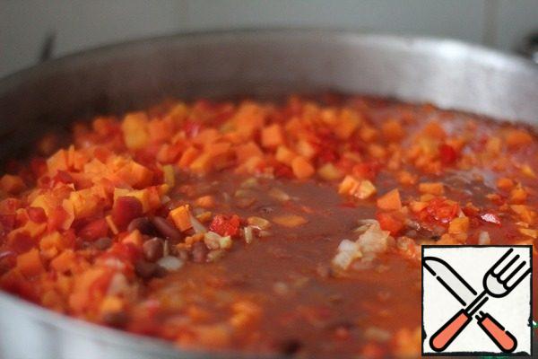 Fry the onion in oil. Add the carrots, onions, and peppers and simmer together until half cooked. Add the vegetables to the beans. Put all the remaining ingredients and cook, after boiling, for 30 minutes.