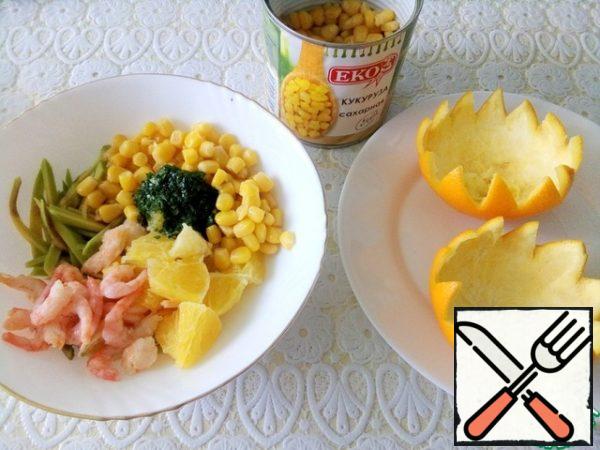 Put everything in a bowl - avocado, shrimp, orange, chopped greens and corn, mix, put everything in baskets from under the orange.