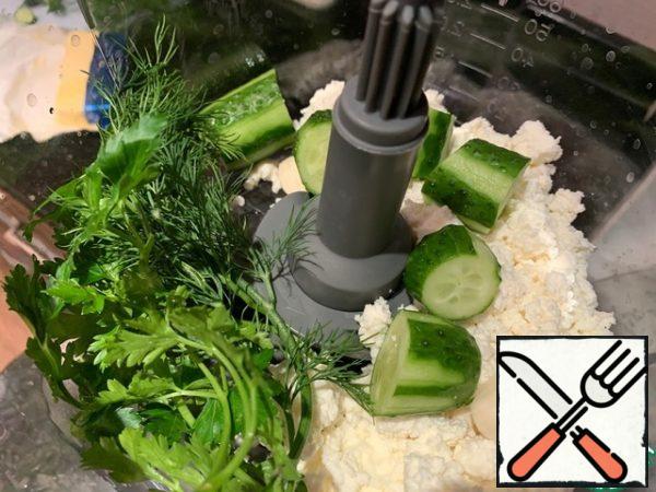 Wash the cucumbers and greens. Put all the ingredients in the bowl of a food processor.