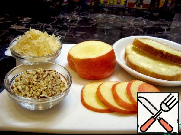 Cut the apple into thin slices, grate the cheese on a coarse grater, chop the nuts, lightly brush the pieces of bread with butter.