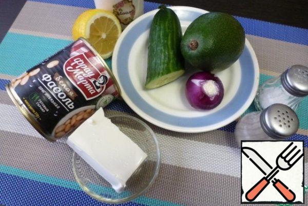 Prepare the ingredients for the salad. Peel the onion and avocado.
Avocado, fresh cucumber and beans should be about the same in volume.
