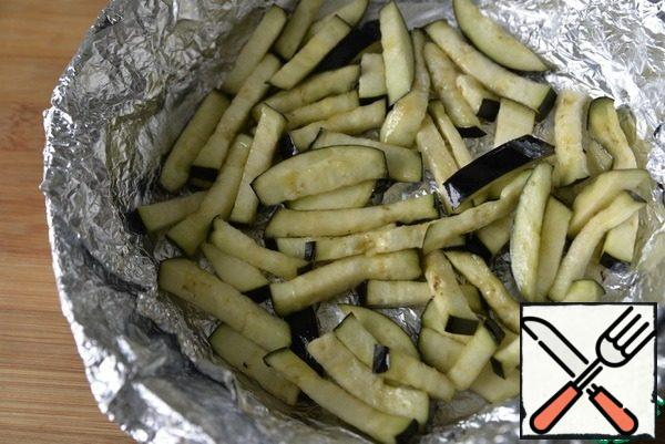 Wash off the eggplant, squeeze it out, soak it with a paper towel, brush it with oil and bake it in a convenient form for 20 minutes at 200 degrees.