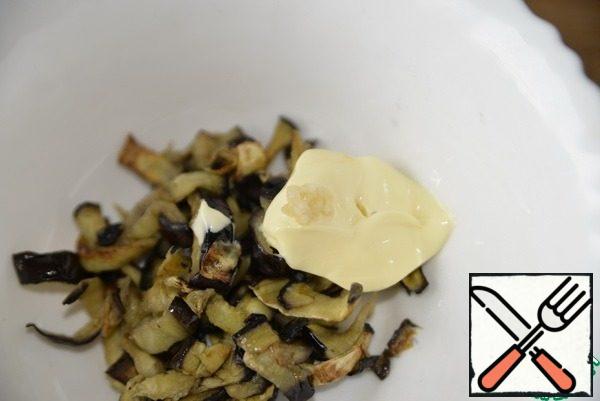 Ready eggplants are allowed to cool, add mayonnaise (sour cream or yogurt), squeeze out garlic, mix. Put the next layer.