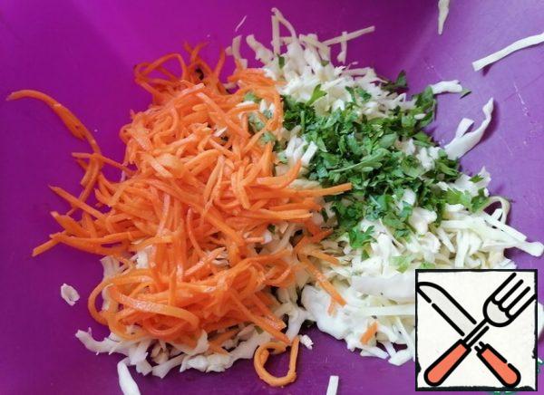 At this time, chop the cabbage, mash it with your hands. Add the chopped parsley and carrots. Then stir.