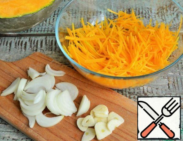 Peel the pumpkin, grate it on a grater for Korean carrots or cut it into thin strips, peel the onion and garlic, cut the onion into feathers, and slice the garlic. Combine the vegetables in a bowl.