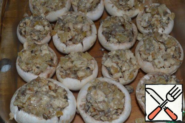 Fill the mushroom caps with minced meat.
Put the mushrooms in a form slightly greased with vegetable oil.