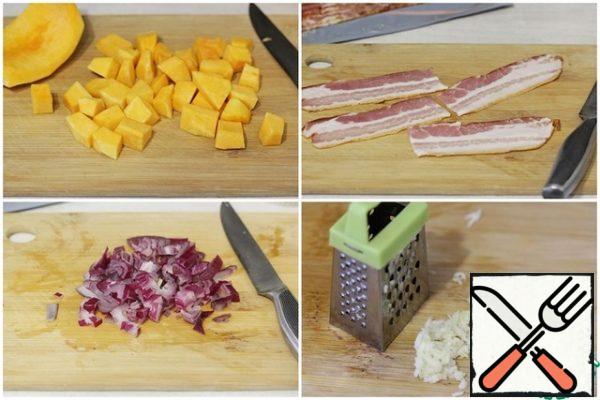 Cut the pumpkin into cubes, finely chop the onion, grate the garlic, leave the bacon strips whole or cut into halves.